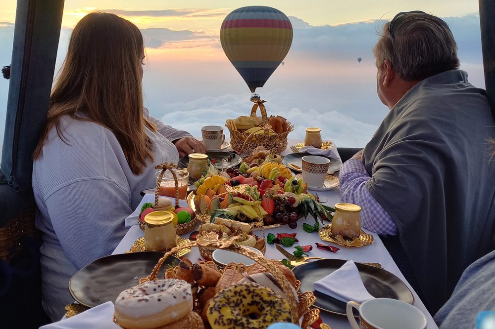 Gourmet breakfast laid out in the basket, above the clouds