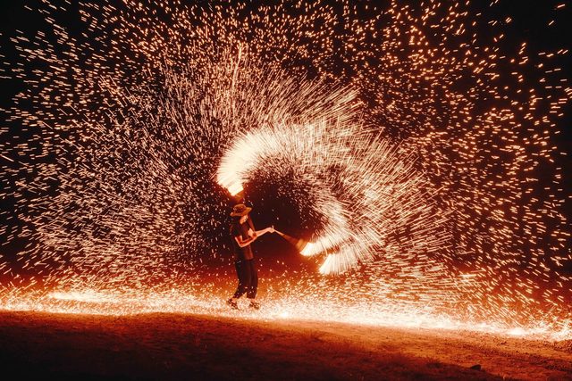 Feuerkünstler und Funkenregen in der Wüstennacht