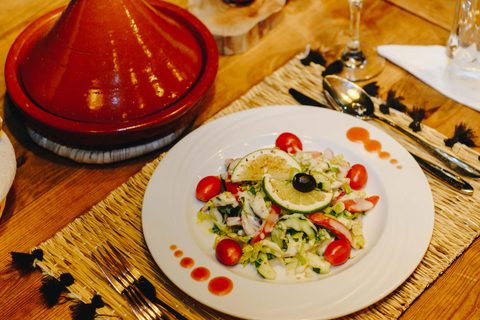 Frischer marokkanischer Salat mit Limette und Kirschtomaten, serviert neben einer Tontajine