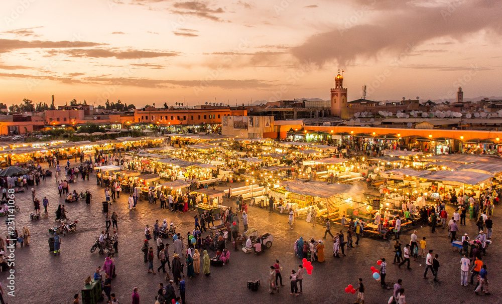 Der Platz Jemaa el-Fna bei Sonnenuntergang, während die Stände aufleuchten